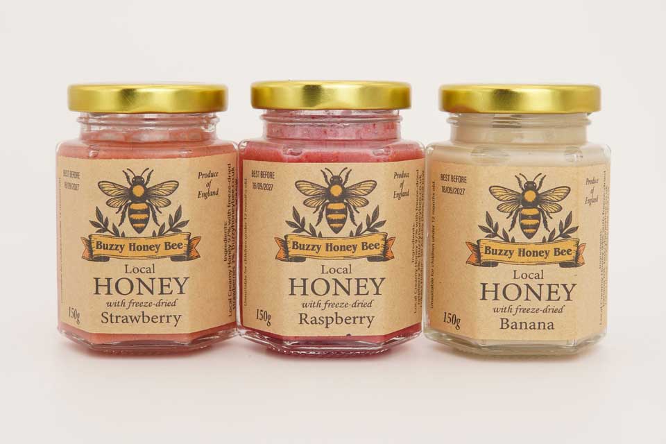Fruit-infused honey jars with freeze-dried strawberry, raspberry and banana showing different colours