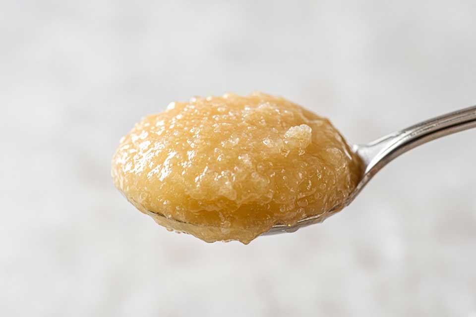 Smooth crystallised raw honey on a spoon