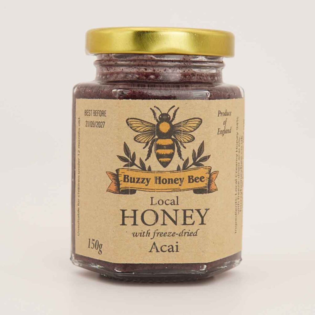 Glass jar of local English honey with freeze-dried acai and a gold lid