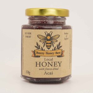 Glass jar of local English honey with freeze-dried acai and a gold lid